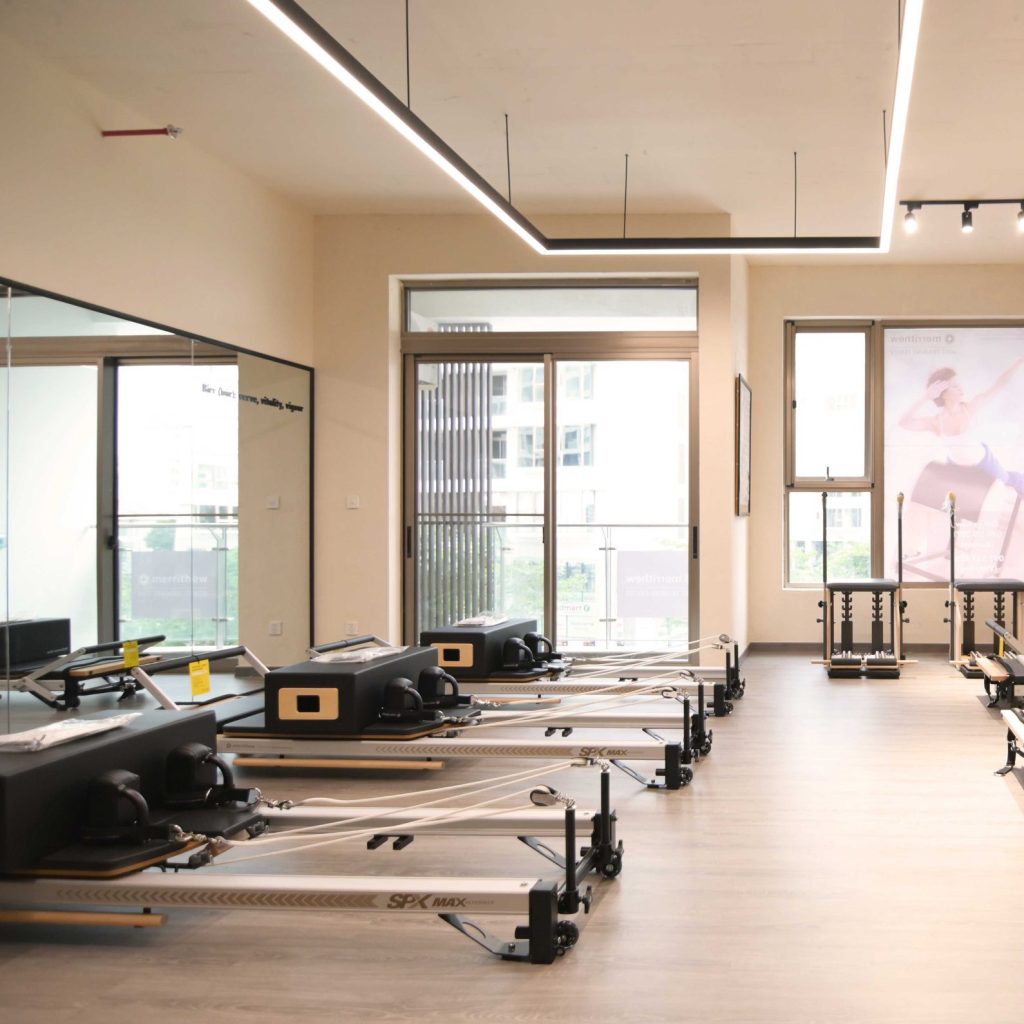 Minimalist Pilates studio with large windows and cream-colored walls